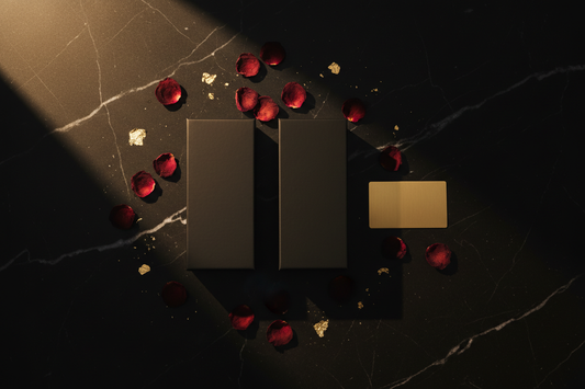 Two elegant black product boxes with rose petals and gold accents on a dark surface — AMARE Edit
